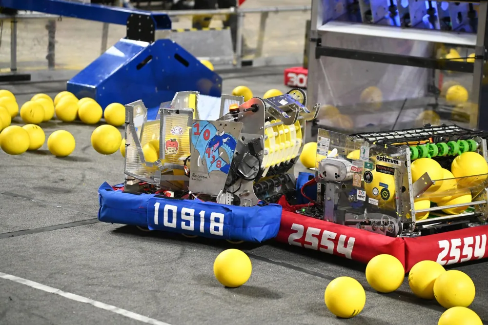 Robot 10918 competing beside robot 2554 on the REBUILT field
